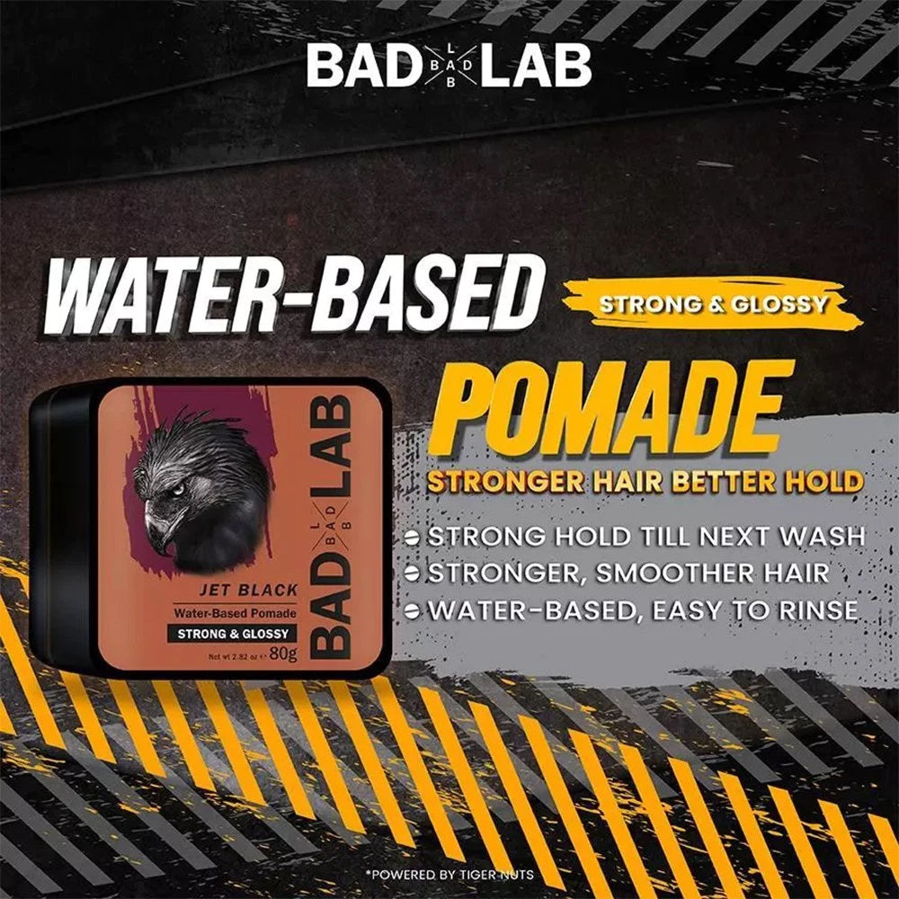 Bad Lab Water-Based Pomade Jet Black container shown on a dark promotional graphic with yellow hazard stripes and text highlighting strong hold and water-based formula.